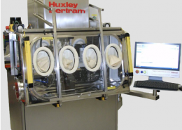 Huxley Bertram Tablet Compaction Simulator with containment to OEB 5 and computer screen showing tableting analysis software