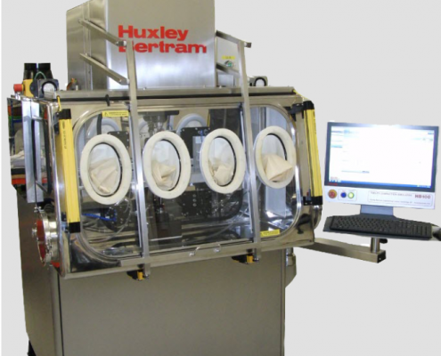 Huxley Bertram Tablet Compaction Simulator with containment to OEB 5 and computer screen showing tableting analysis software