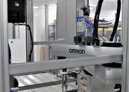 Omron SCARA robotic arm integrated into a product assembly machine with ultrasonic welding capability