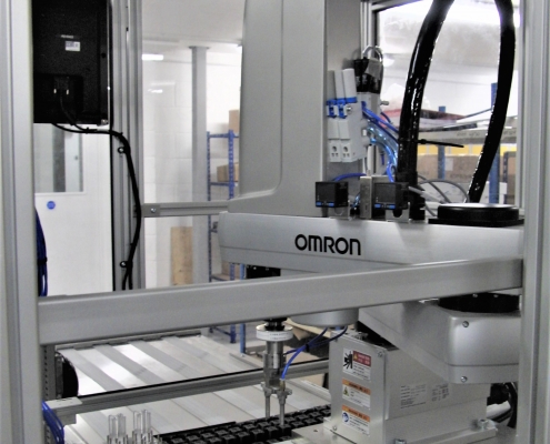 Omron SCARA robotic arm integrated into a product assembly machine with ultrasonic welding capability